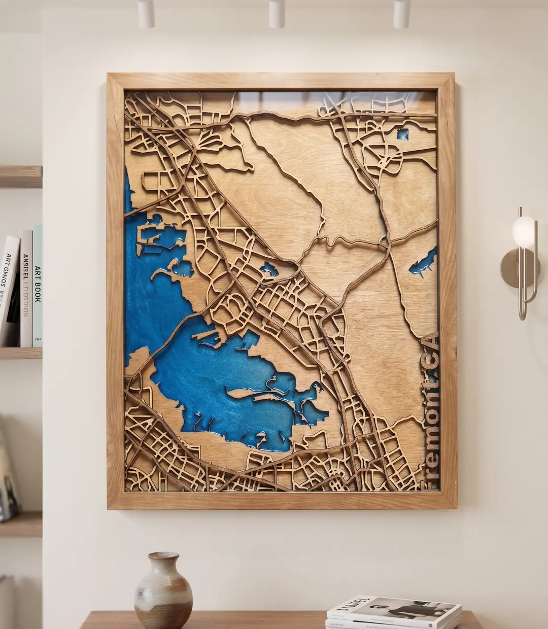 Large framed layered map artwork styled in a warm interior above a console table.